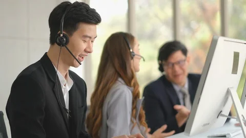 Handsome operator is working while his co-worker content with their work Stock Footage 127900902