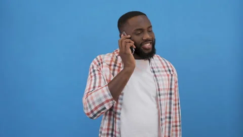 Handsome over isolated blue wall keeping a conversation with the mobile phone 4K Stock Footage 117507604