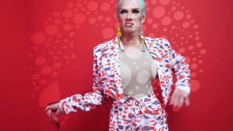 Handsome parody actor on a red background with light filters manipulates a red Stock Footage 167184907