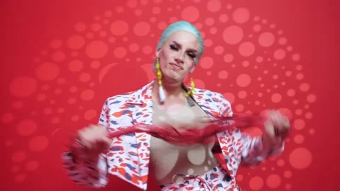 Handsome parody actor on a red background with light filters manipulates a red Vidéo 167612980