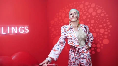 Handsome parody actor on a red background with light filters manipulates a red Stock Footage 167696392