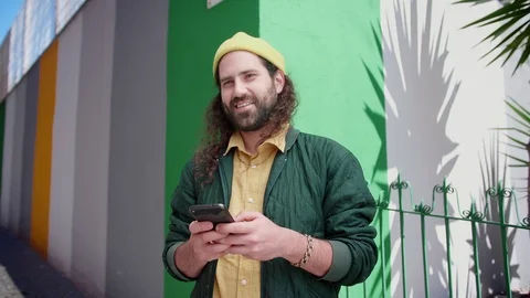 Handsome pensive bearded man using black smartphone answering to messages in Stock Footage 108427800