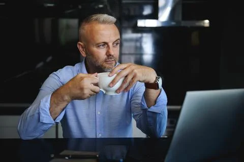 Handsome pensive businessman, charming middle aged man with cup of coffee loo Stock Photos