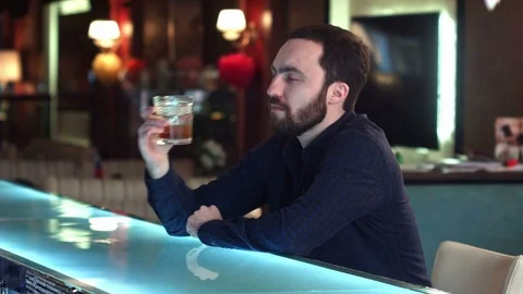 Handsome pensive guy is looking forward and thinking while sitting at the bar Stock Footage 76601739