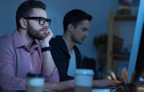 Handsome pensive programmer working on the computer Stock Photos