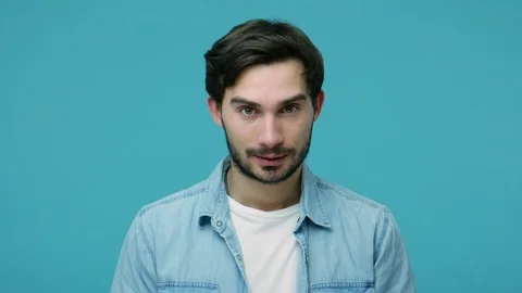 Handsome positive young bearded guy in jeans shirt smiling and winking playfully Stock Footage 126073671