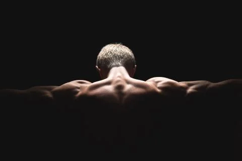 Handsome power athletic man in dramatic light. Strong bodybuilder with perfect Stock Photos