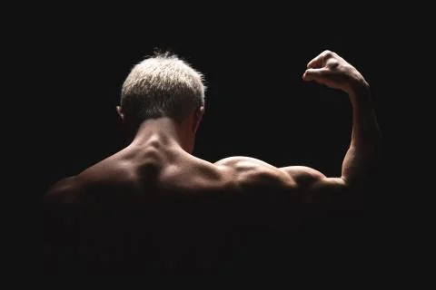 Handsome power athletic man in dramatic light. Strong bodybuilder with perfect Stock Photos