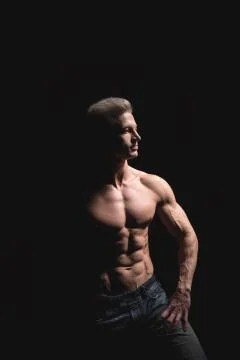 Handsome power athletic man in dramatic light. Strong bodybuilder with perfect Stock Photos