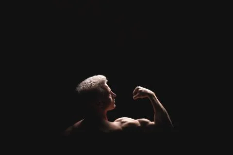 Handsome power athletic man in dramatic light. Strong bodybuilder with perfect Foto stock