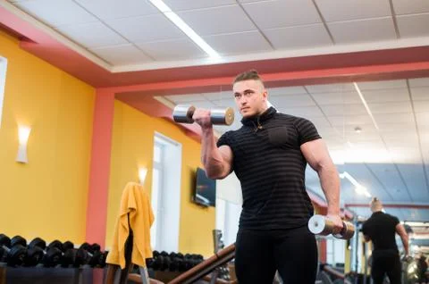 Handsome powerful athletic man doing barbell shoulder press exercise. Strong Stock Photos