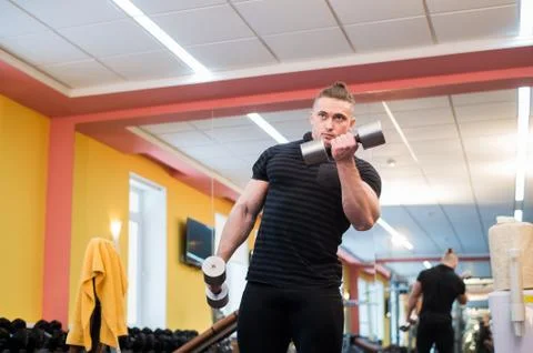 Handsome powerful athletic man doing barbell shoulder press exercise. Strong Stock Photos