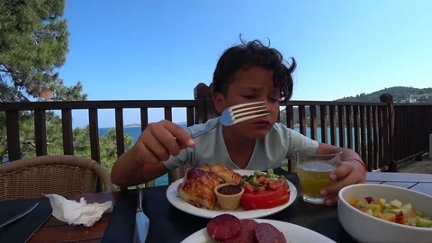 Handsome preteen eating breakfast at the outdoor 5 Stock Footage