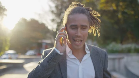 Handsome professional with dreadlocks walks and talk on his phone, in slow motio Stock Footage 116421247