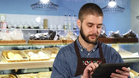 Handsome professional male baker using digital tablet at his store Stock-Footage 84762221