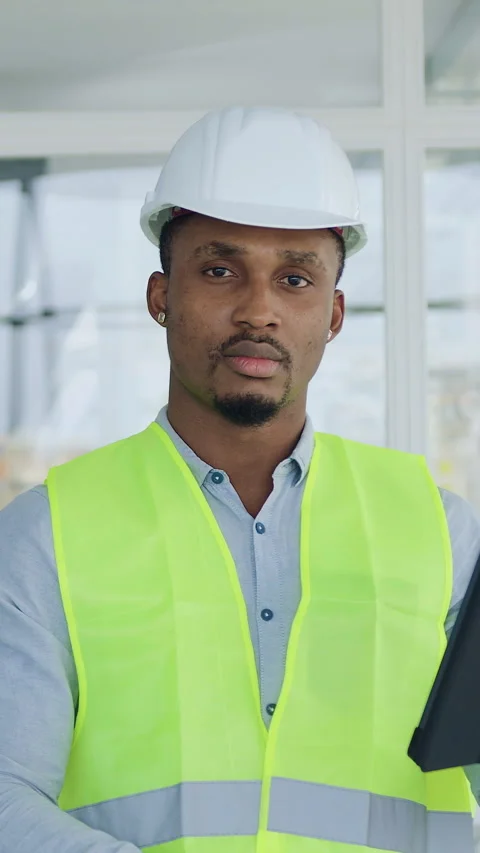Handsome purposeful skilled 35-aged black-skinned engineer in protective hardhat Stock Footage 327929177