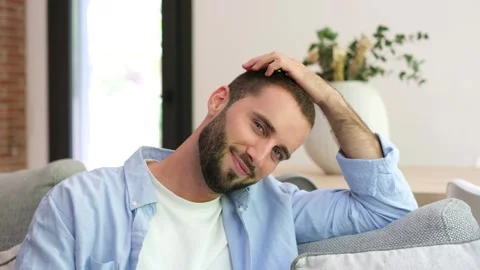 Handsome relaxed young man smiling at home Stock Footage 335588492