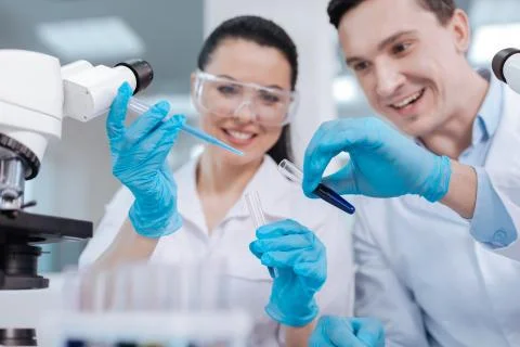 Handsome scientist expressing positivity while doing experiment Stock Photos