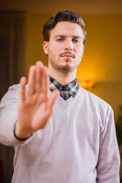 Handsome, seerious young man doing stop sign with hand Stock Photos