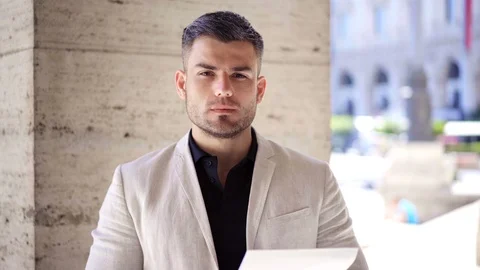 Handsome self-confident man looking positively on camera on the street Stock-Footage 108758827