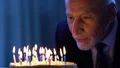 Handsome senior male looking at birthday cake making wish, holiday celebration HD Footage