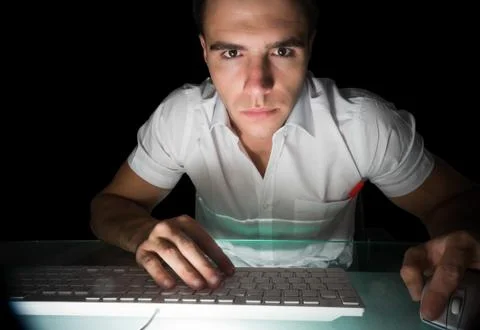 Handsome serious computer engineer working at night Stock Photos