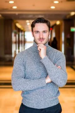 Handsome serious man standing inside modern building Foto stock