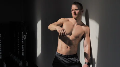 Handsome shirtless muscular man posing against wall Stock Footage 101485146