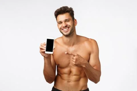 Handsome shirtless sportsman advertise smartphone application. Sexy smiling Stock Photos