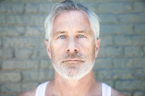 Handsome Silver Haired Man in front of Brick Wall Stock Photos