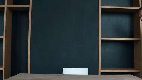 Handsome sitting down by the table and starts reading a book Stock Footage 95919389