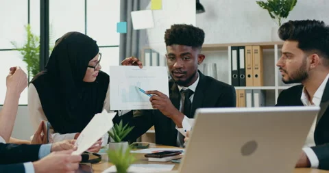 Handsome skilled black-skinned man explaining financial report to another Stock Footage 159653040