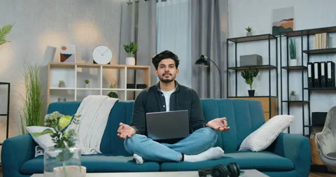 Handsome smiling calm bearded guy with laptop on his knees sitting in relaxed Stock Footage 150117662