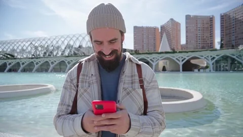Handsome smiling Caucasian man using mobile in science park in Valencia city Stock Footage 261341838