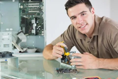 Handsome smiling computer engineer repairing hardware with pliers Stock Photos