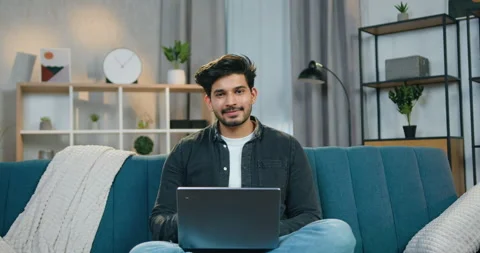 Handsome smiling confident smart bearded guy in casual clothes sitting in Stock Footage 150118655