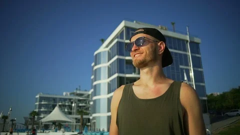 Handsome smiling man sunglasses beard stay seaside sunny rapid slow motion Stock Footage