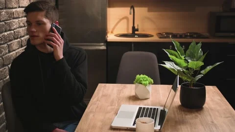 Handsome smiling man talking mobile phone at home office. Man having phone call Stock Footage 148384261
