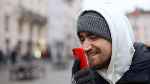 Handsome smiling man using red smartphone touchscreen tapping by nose to unlock  스톡 동영상 121307076