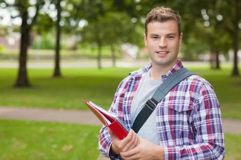 Handsome smiling student carrying folder Stock Photos