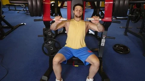 Handsome sporty man is exercising in gym centre Stock Footage