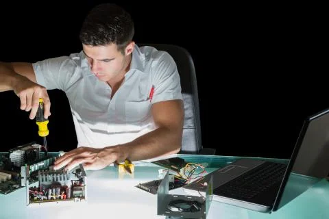 Handsome stern computer engineer working by night with screw driver Stock Photos