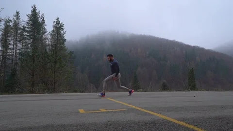 A handsome strong man with athletic body doing stretching exercises for legs on Stock Footage 122437168
