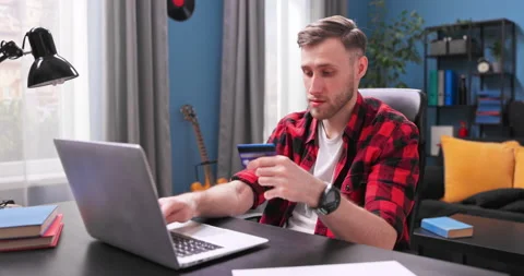 Handsome student boy types credit card number on an online store website. A 스톡 동영상 153876653