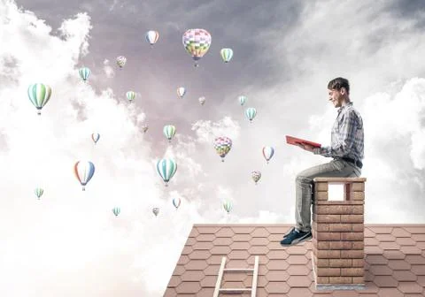 Handsome student guy reading book and aerostats flying in air Stock Photos