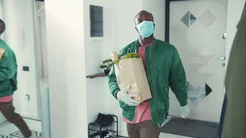 Handsome stylish man coming back home after food shopping. Young african guy Stock Footage 131670685