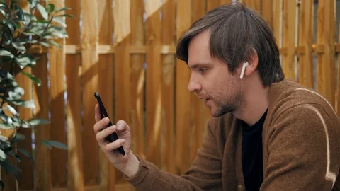 Handsome stylish man leaving message using voice recognition, speaking at Stock-Footage 97854448