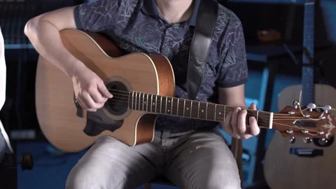 Handsome talented guy with a beard plays an acoustic guitar in a music studio Stock Footage 138463335
