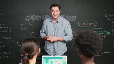 Handsome teacher teaching engineering code to diverse student. Edification Stock Footage 273938715