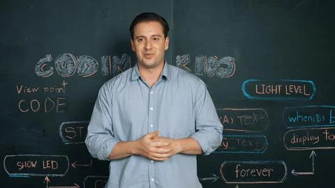 Handsome teacher teaching engineering code while standing at board. Edification. 스톡 사진